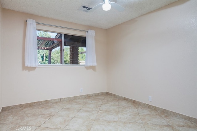 tiled spare room with a textured ceiling and ceiling fan