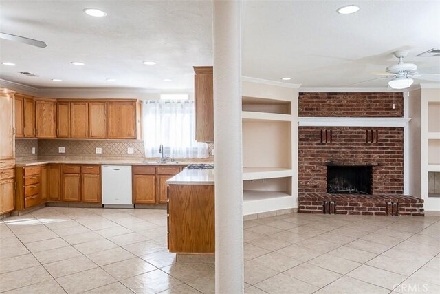 kitchen featuring ceiling fan, light tile patterned floors, white dishwasher, a brick fireplace, and built in shelves