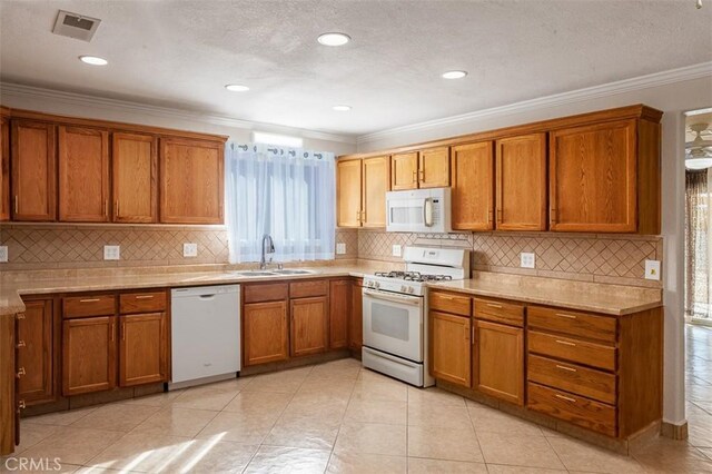 kitchen featuring white appliances, sink, backsplash, ornamental molding, and light tile patterned floors