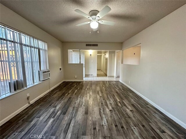 spare room with dark wood-type flooring, a textured ceiling, and ceiling fan