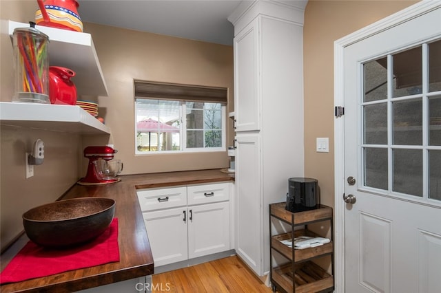 interior space featuring white cabinetry, light hardwood / wood-style flooring, and wood counters