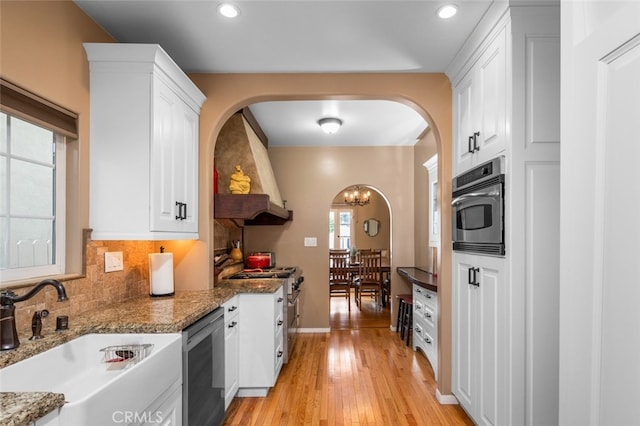 kitchen with white cabinetry, dark stone counters, light hardwood / wood-style flooring, sink, and stainless steel appliances