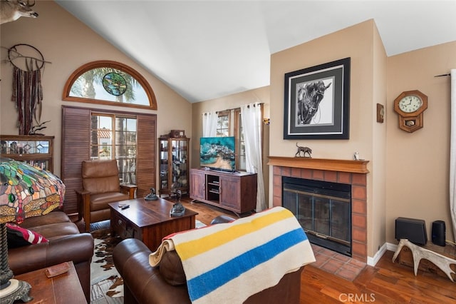 living room featuring high vaulted ceiling, hardwood / wood-style flooring, and a tile fireplace