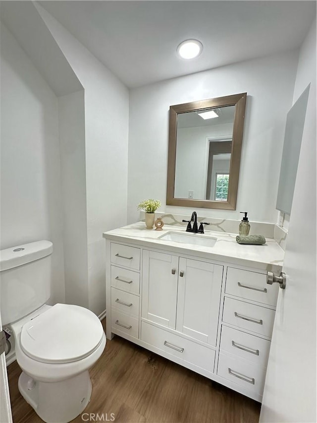 bathroom featuring hardwood / wood-style flooring, vanity, and toilet