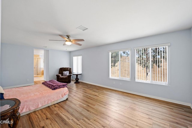 bedroom with connected bathroom, ceiling fan, and light wood-type flooring