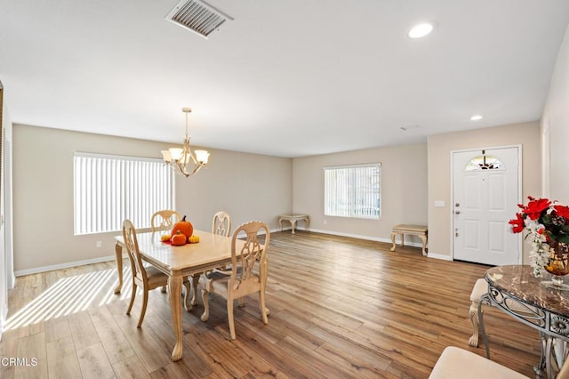 dining room with a chandelier and light hardwood / wood-style flooring