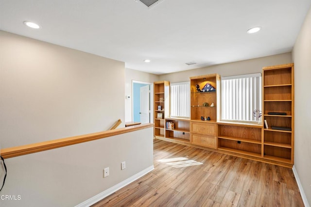 spare room with baseboards, recessed lighting, and light wood-style floors