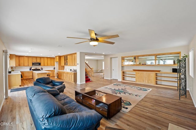 living area with light wood finished floors, stairs, baseboards, and recessed lighting