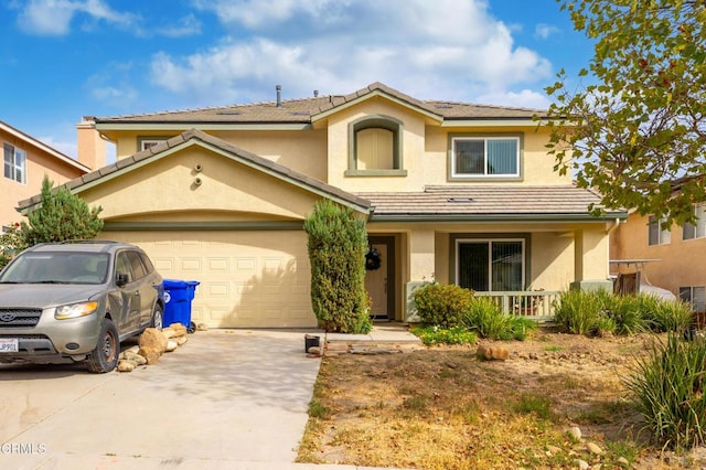 view of front of property with a garage, covered porch, driveway, a tiled roof, and stucco siding