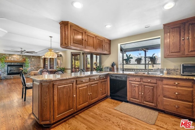 kitchen with dishwasher, sink, light wood-type flooring, a fireplace, and kitchen peninsula