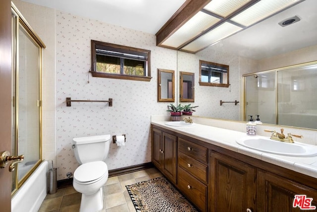 full bathroom featuring tile patterned flooring, vanity, toilet, and bath / shower combo with glass door