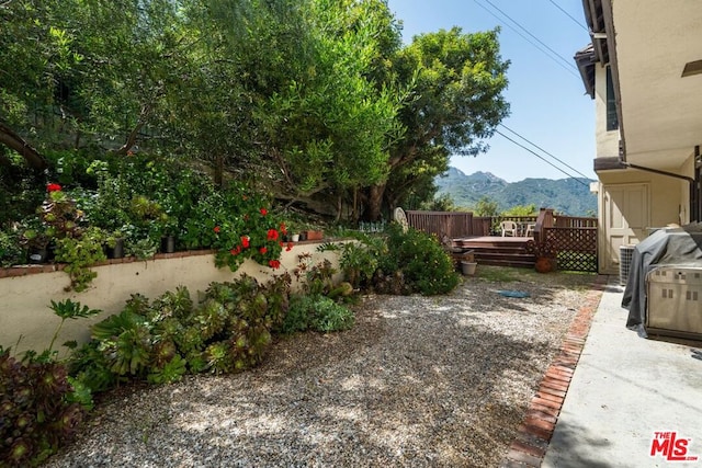 view of yard with a deck with mountain view