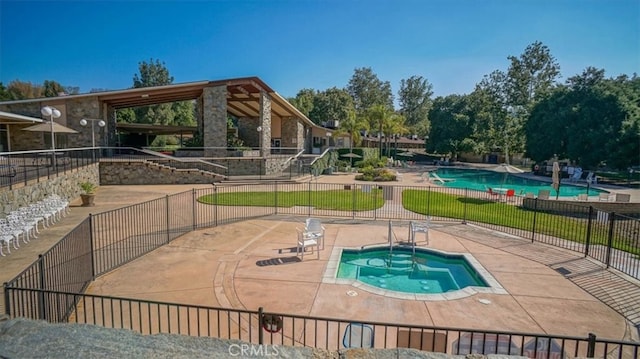 view of swimming pool featuring a community hot tub and a patio area