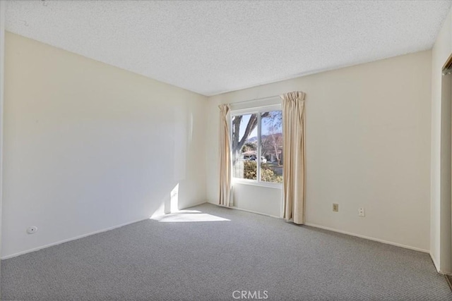 carpeted empty room with a textured ceiling