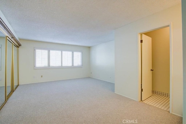 carpeted spare room featuring a textured ceiling