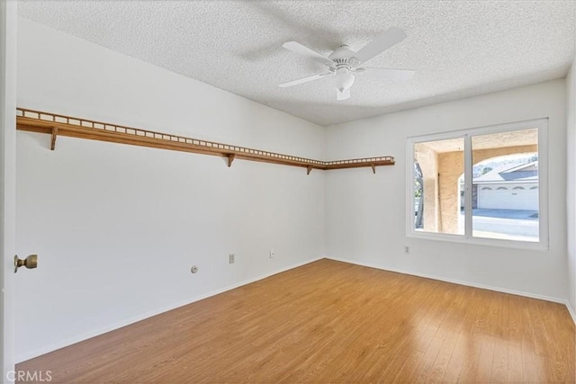 empty room featuring ceiling fan, a textured ceiling, and light hardwood / wood-style flooring