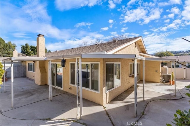 back of property with cooling unit and a patio