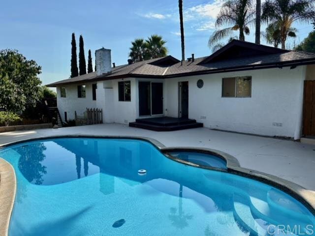 view of swimming pool featuring a patio area and an in ground hot tub