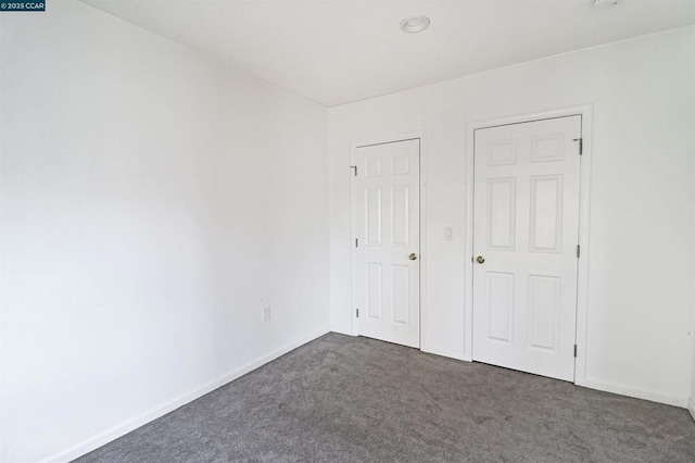 unfurnished bedroom featuring dark colored carpet