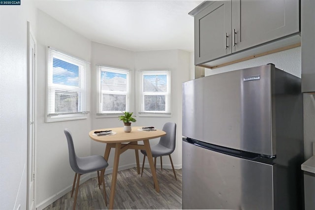 kitchen with dark hardwood / wood-style floors, stainless steel refrigerator, and gray cabinets