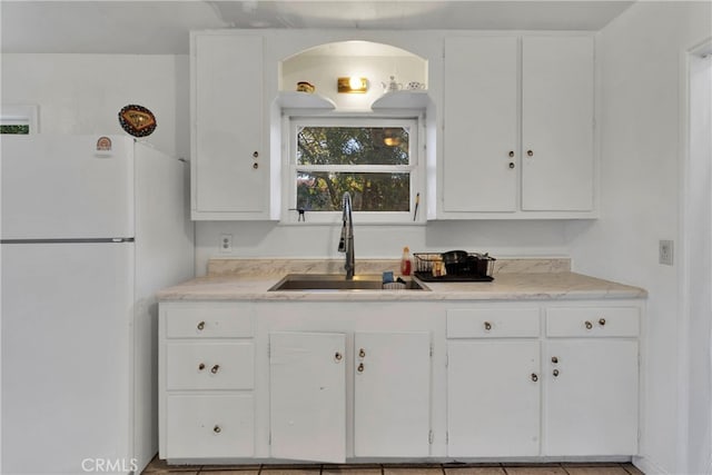 10394 Baker Rd, Lucerne Valley, CA 92356 - kitchen featuring white fridge, light tile patterned flooring, sink, and white cabinets