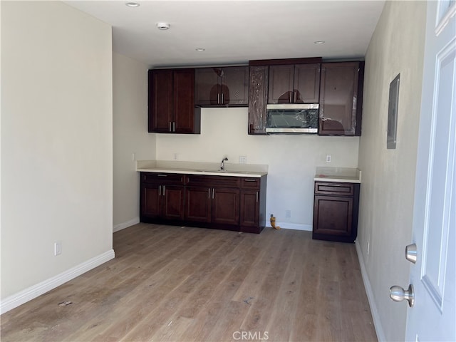 kitchen featuring sink, light hardwood / wood-style flooring, and dark brown cabinetry