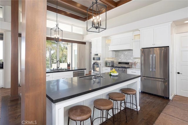 kitchen featuring dark countertops, custom range hood, decorative backsplash, a sink, and high quality appliances