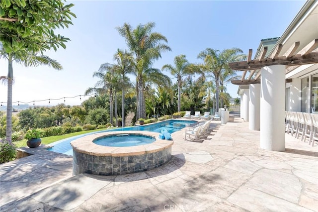 view of swimming pool featuring a pool with connected hot tub and a patio