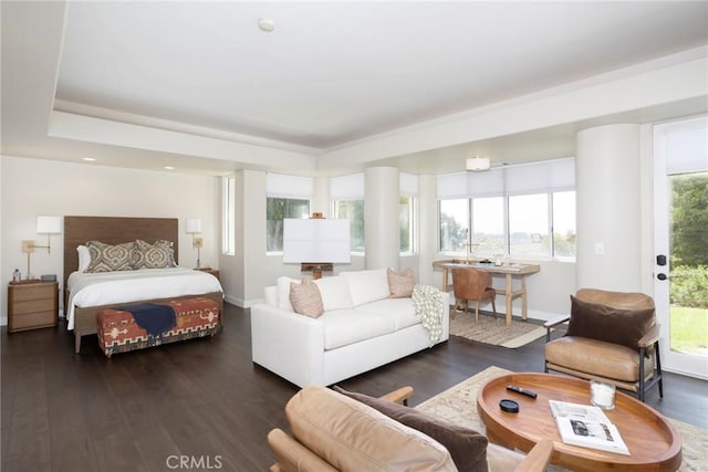 bedroom with access to outside, multiple windows, wood finished floors, and baseboards