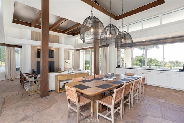 dining space featuring a high ceiling and stone tile flooring