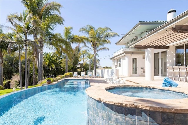 pool featuring a patio, french doors, fence, and an in ground hot tub