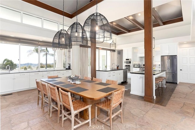 dining area featuring stone finish floor, visible vents, and a high ceiling