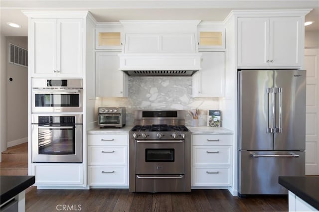 kitchen with visible vents, decorative backsplash, glass insert cabinets, stainless steel appliances, and white cabinetry