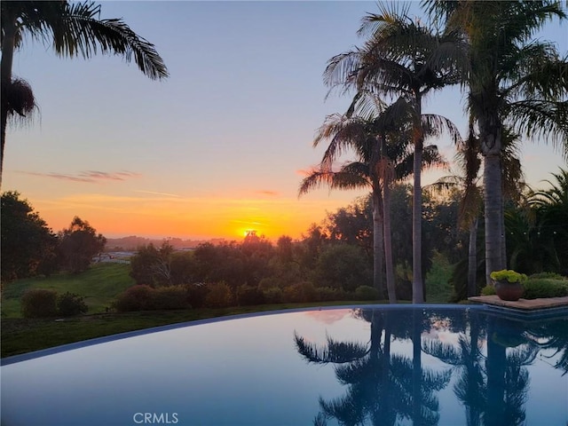 pool at dusk featuring an outdoor pool