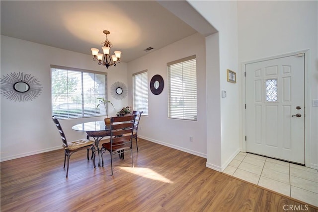 dining space featuring light hardwood / wood-style floors and a notable chandelier