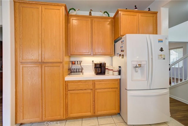 kitchen featuring light tile patterned flooring and white refrigerator with ice dispenser