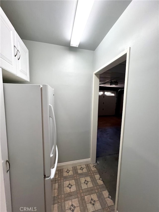 kitchen with white fridge and white cabinetry