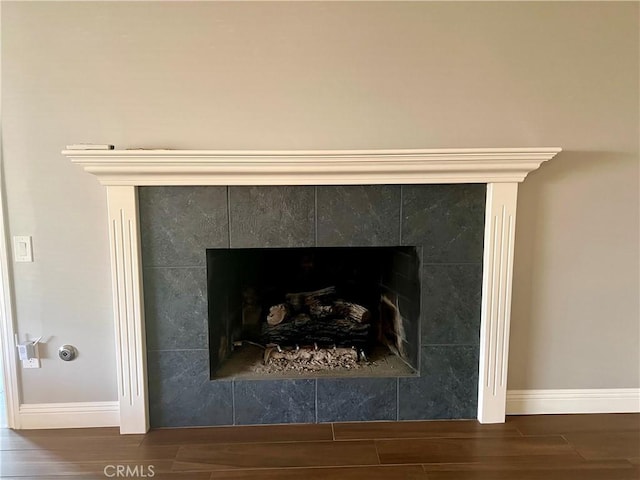 details featuring hardwood / wood-style floors and a tiled fireplace