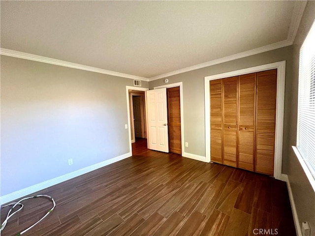 unfurnished bedroom featuring ornamental molding, dark wood-type flooring, and a closet