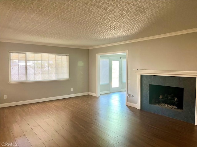 unfurnished living room featuring a tile fireplace, plenty of natural light, and hardwood / wood-style floors