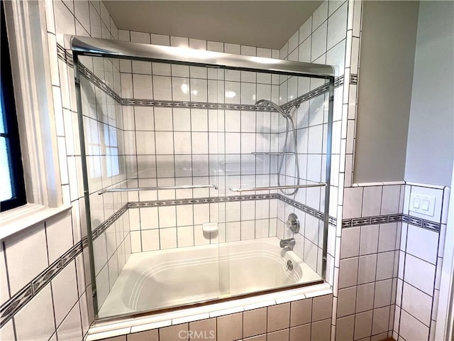 bathroom with bath / shower combo with glass door