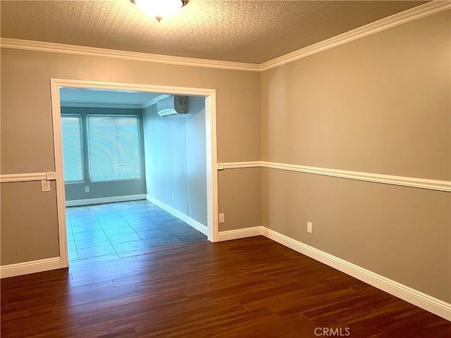 spare room featuring a textured ceiling, dark hardwood / wood-style floors, an AC wall unit, and crown molding