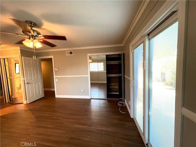 unfurnished room featuring ceiling fan, dark wood-type flooring, and ornamental molding