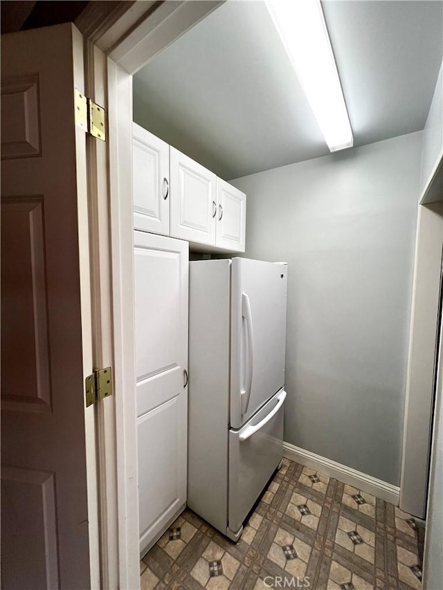 kitchen featuring white fridge and white cabinetry