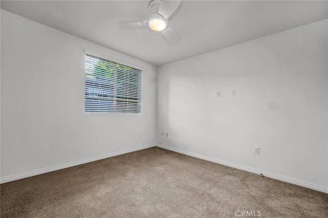 carpeted spare room featuring ceiling fan