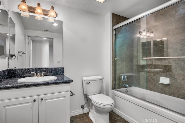 full bathroom featuring toilet, bath / shower combo with glass door, vanity, and tile patterned flooring