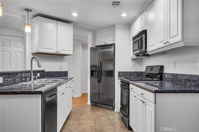 kitchen with appliances with stainless steel finishes, white cabinets, decorative light fixtures, and sink