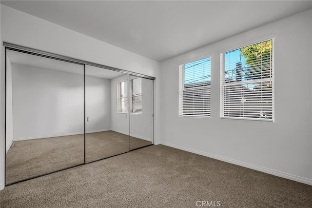 unfurnished bedroom with a closet and carpet floors