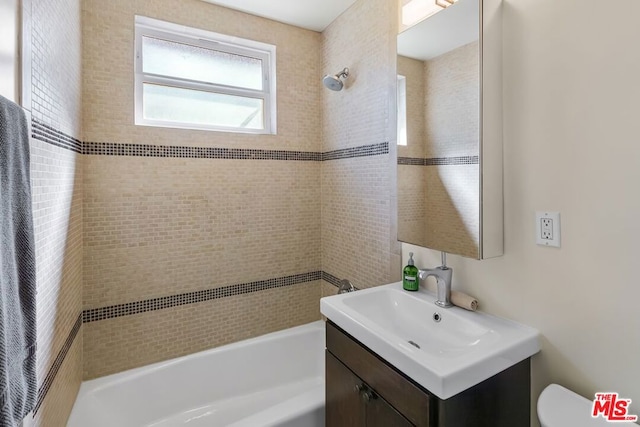 full bathroom featuring vanity, toilet, and tiled shower / bath