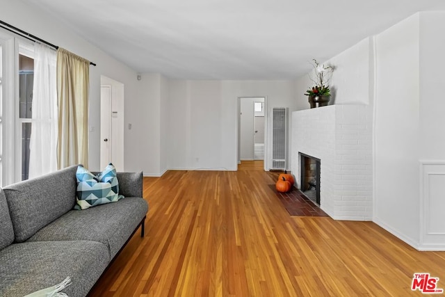 living room with wood-type flooring and a fireplace